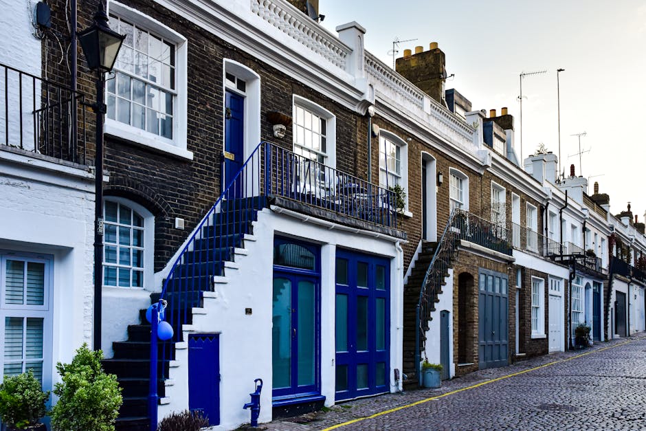 A row of elegant, white Victorian terrace houses in Belsize Park, NW3, featuring detailed architectural facades with arched windows, decorative cornices, and balconies. The street scene includes parke